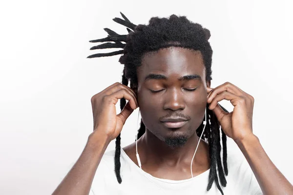 Uomo dalla pelle scura con dreadlocks ascoltare musica su cuffie — Foto Stock