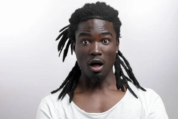 Sorprendido hombre afroamericano vistiendo camiseta blanca mirando a la cámara en sorpresa — Foto de Stock