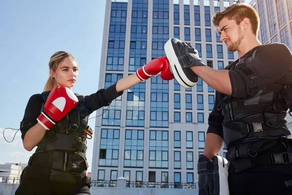 Zwei junge Leute trainieren mit Boxhandschuhen auf der Straße — Stockfoto
