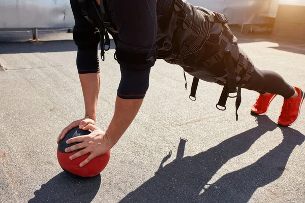 Närbild av beskurna fotot av en fit sportig man träning med en boll — Stockfoto