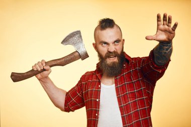 agresif oduncu. Baltayla sallanan sakallı adam