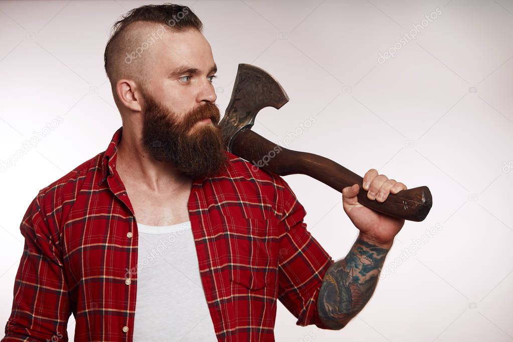 mohawk bearded male holds axe on his shoulder on white background