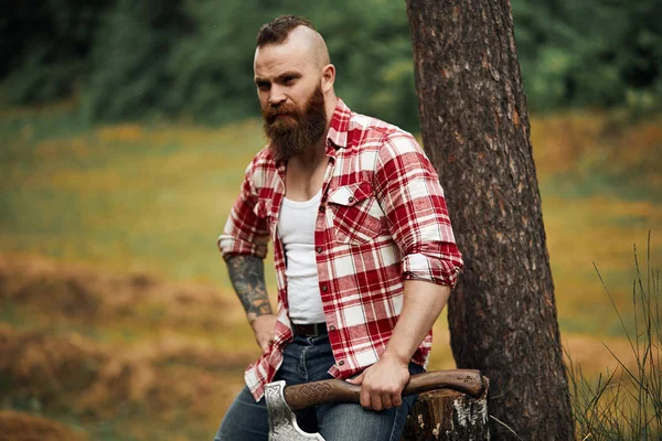 Lumberjack sitting in forest resting after hard work — Stock Photo, Image