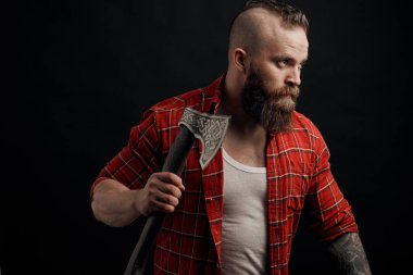 agresif oduncu. Baltayla sallanan sakallı adam