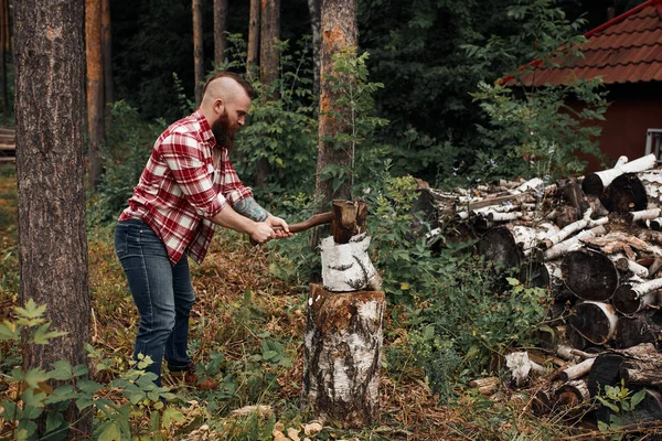 Woodcutter in shirt chopping firewoods, chips fly apart — Stock Photo, Image