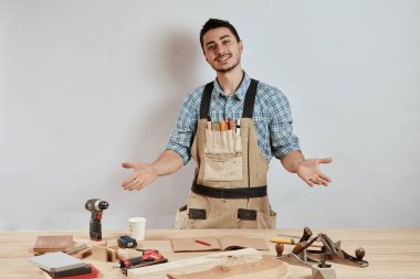 Duygusal erkek marangoz iş giysisi ve şaşkın bakmak karışık önlük
