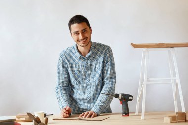 Marangoz adam araçları ile masada kalem kullanarak taslak planı yapma