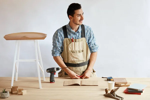 Carpinteiro homem fazendo plano de rascunho usando lápis na mesa com ferramentas — Fotografia de Stock