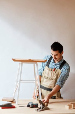 Bir marangozun eli ahşap bir tahtanın ölçüsünü alıyor.