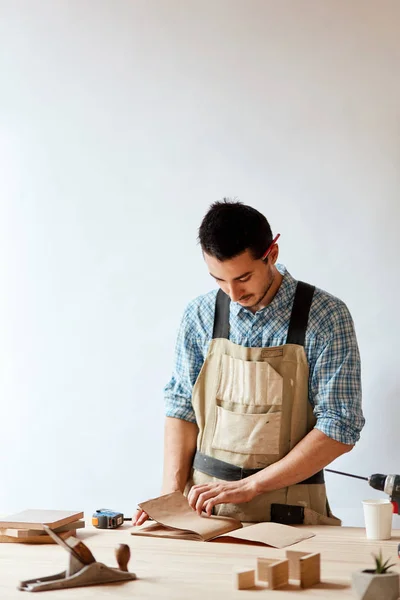 Closeup view of a carpenter using a red pencil to draw a line on a blueprint — Stock Photo, Image