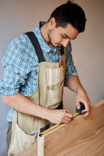 Mão de um carpinteiro que toma a medida de uma prancha de madeira — Fotografia de Stock