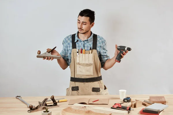 Maschio carpentiere emotivo in abbigliamento da lavoro e grembiule dopo aver confuso sguardo perplesso — Foto Stock