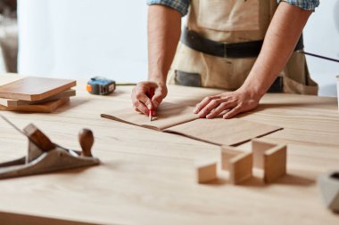 portre görünümünde bir plan üzerinde bir çizgi çizmek için kırmızı bir kalem kullanarak bir marangoz