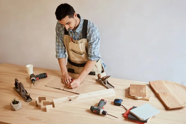 Hombre haciendo borrador plan usando lápiz sobre la mesa con herramientas — Foto de Stock