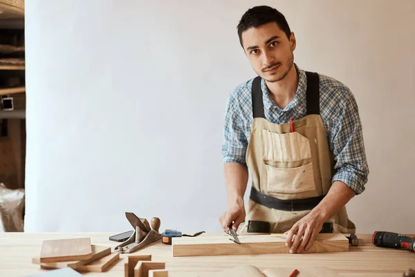 Bir marangozun eli ahşap bir tahtanın ölçüsünü alıyor. — Stok fotoğraf