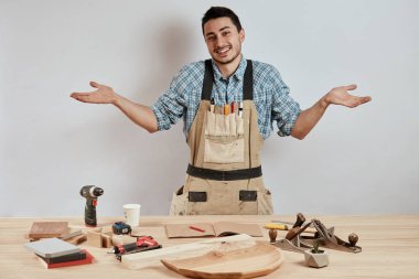 Duygusal erkek marangoz iş giysisi ve şaşkın bakmak karışık önlük