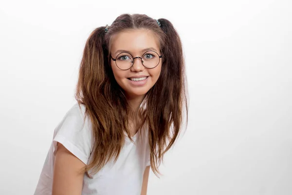 Positieve ontzagwekkend vrouw in brillen en witte T-shirt kijken naar de camera — Stockfoto