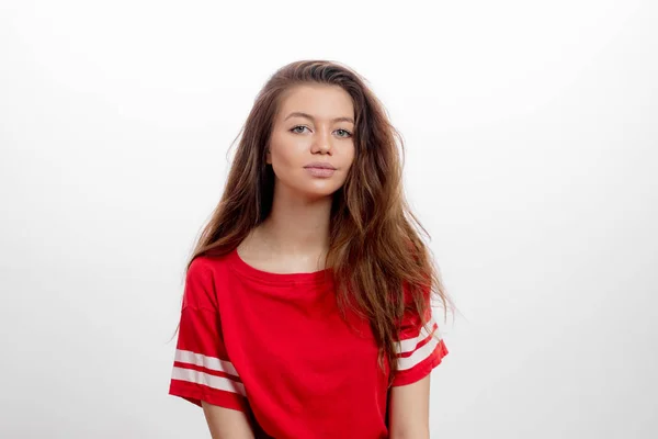 Потрясающая молодая женщина с длинными прямыми каштановыми волосами в красной футболке — стоковое фото