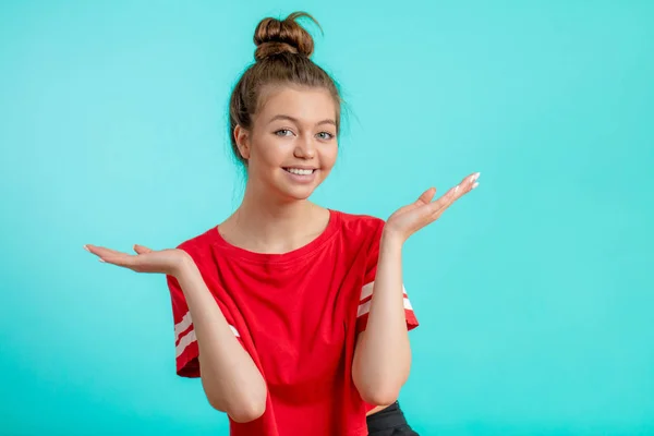 Sonriente chica positiva con hairbun presentando nuevo producto . — Foto de Stock