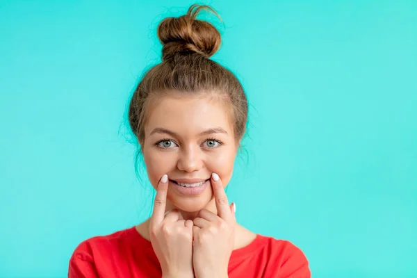 Beautiful girl with a fake smile looking at the camera — Stock Photo, Image