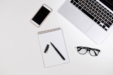 Ofis Masası Not defteri, Macbook, kalem, gözlük ve akıllı telefon