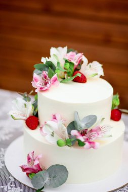 Lezzetli düğün pastası beyaz buzlanma egzotik çiçekler ile dekore edilmiştir.