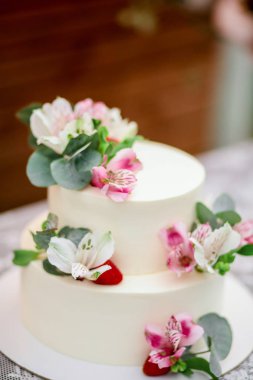 Lezzetli düğün pastası beyaz buzlanma egzotik çiçekler ile dekore edilmiştir.