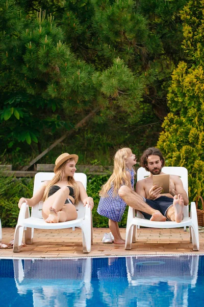 Casal com filha em férias usando Digital Tablet perto de piscina — Fotografia de Stock