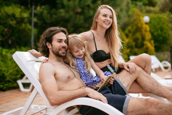 Casal com filha em férias usando Digital Tablet perto de piscina — Fotografia de Stock