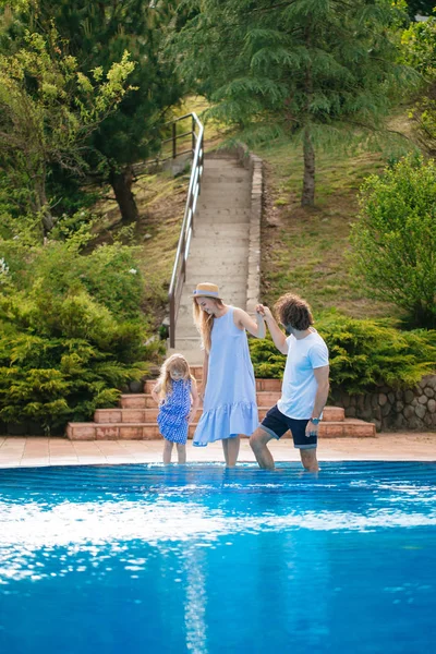 Férias em família no verão. Pais com criança se divertindo perto da piscina — Fotografia de Stock