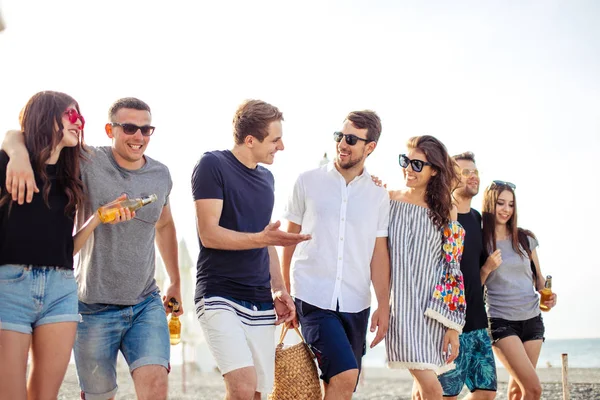 Vacaciones, vacaciones. grupo de amigos divirtiéndose en la playa, caminando, bebiendo cerveza, sonriendo y abrazándose —  Fotos de Stock