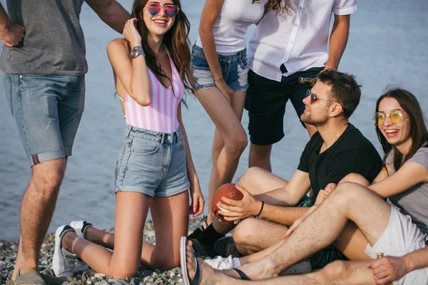 Gente pasando un buen rato juntos mientras están sentados en la playa, divirtiéndose y bebiendo cerveza —  Fotos de Stock