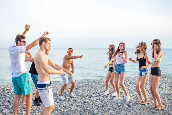 Amigos dançam na praia sob a luz do sol, se divertindo, feliz, desfrutar — Fotografia de Stock