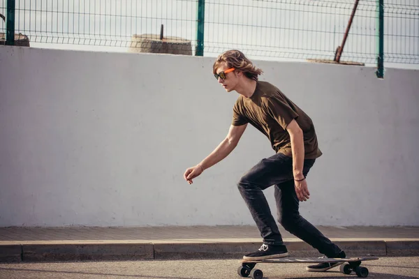 Jongen longboard rijden op boardwalk, warme zomertijd — Stockfoto