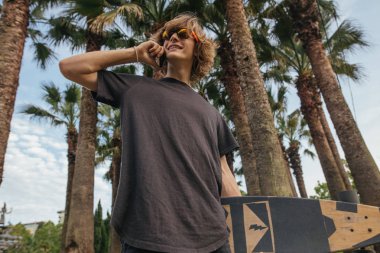 el ile Longboard yürümek ve konuşmak telefon kaykaycı