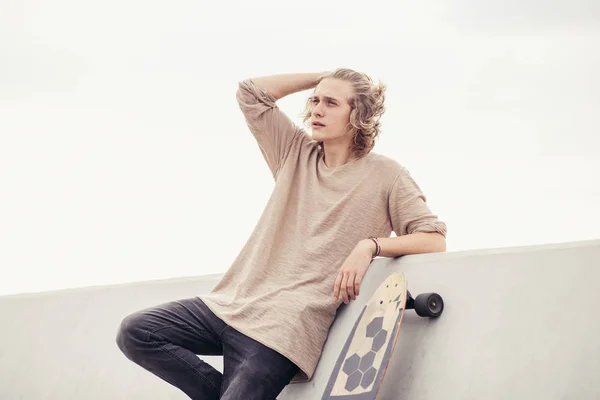Мужская сторона в футболке с деревянной доской на бетонной стене — стоковое фото