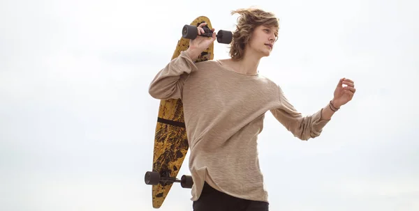 stock image man standing with skateboard on his shoulder and looking aside