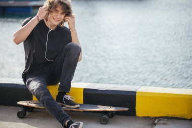 ile longboard Street pier yat ile üzerine oturan adam