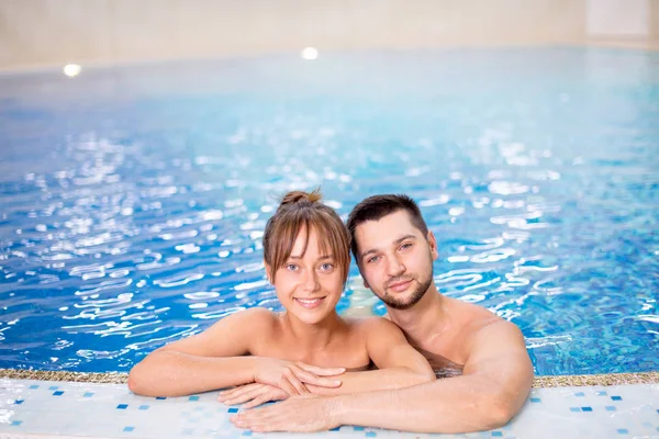 Jovem positivo e mulher posando para a câmera enquanto estava na piscina — Fotografia de Stock
