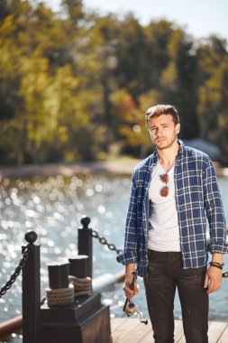 çubuk ve gölde balık tutma güneş gözlüğü ile genç balıkçı