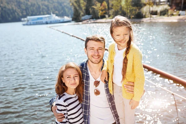 Mutlu Aile sessiz göldeki iskelede poz verirken kameraya bakıyor.