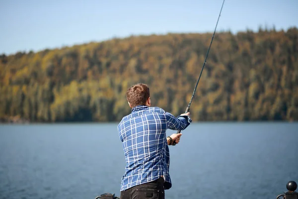 Fischer steht am Ufer und versucht, Fische zu fangen — Stockfoto