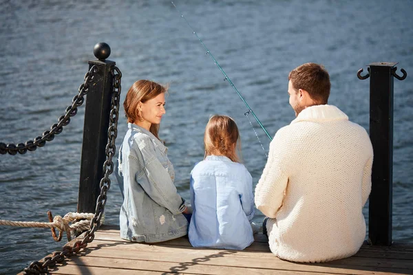 Família feliz com a filha de pesca na lagoa no outono — Fotografia de Stock