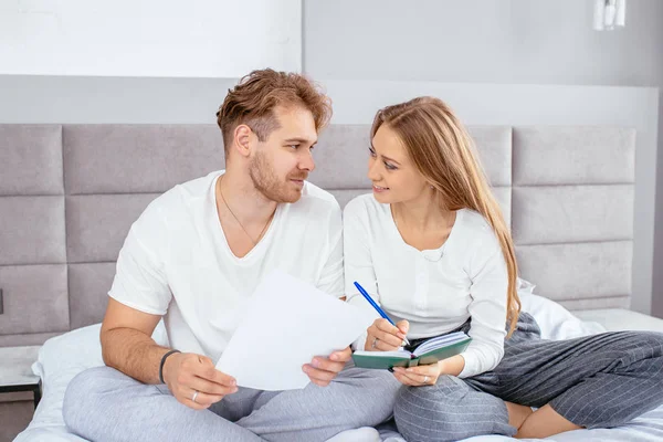 Twee lyoung aangename mensen zijn in liefde. ze schrijven uitnodigingskaarten voor bruiloft — Stockfoto