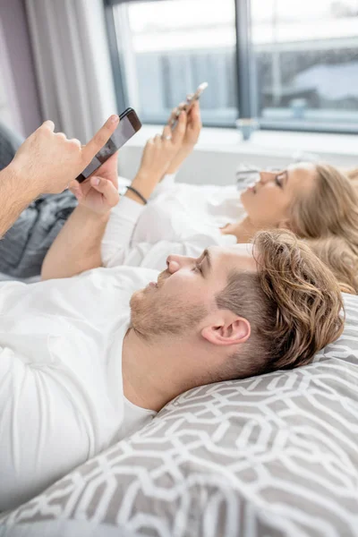 nice young people are surfing the Internet while resting on the bed