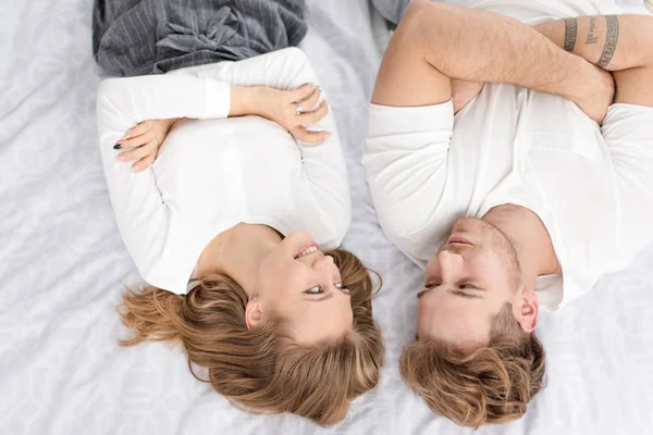 Pozitivní pár leží v posteli lidí. Láska. Veselé. Mladá. Dospělý. Romantický. — Stock fotografie