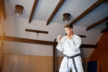 Kara kuşak eğitimi karate salonunda beyaz kimono içinde adam