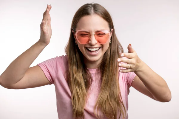 Close up portrait of a laughing, happy woman in pink sunglasses. — Stok Foto