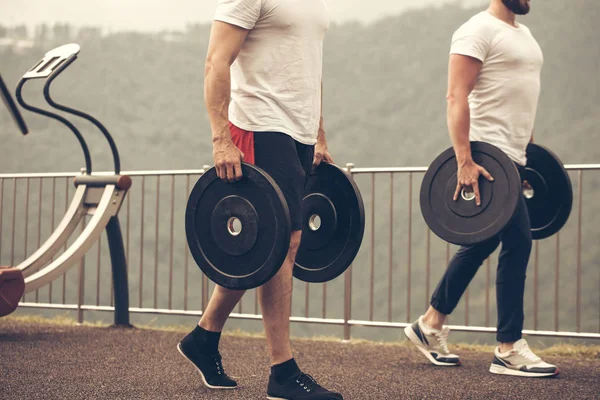Hombres musculosos caucásicos con placas de peso que se preparan para el entrenamiento al aire libre. — Foto de Stock