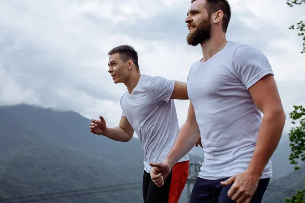 Morgentraining, sportliche Männer, die in den Bergen laufen und einen gesunden Lebensstil leben — Stockfoto